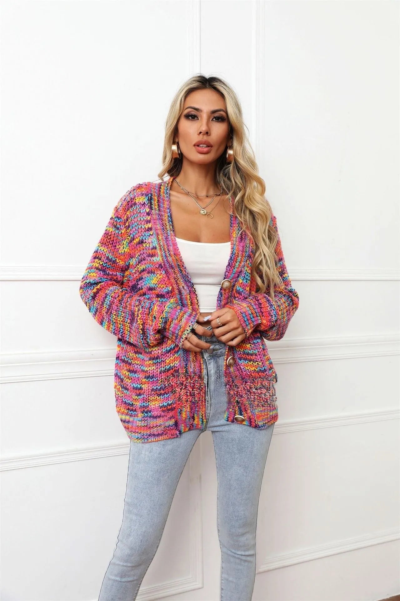 Rose red loose fit knitted cardigan coat with rainbow coloured stripes, shown on a model.