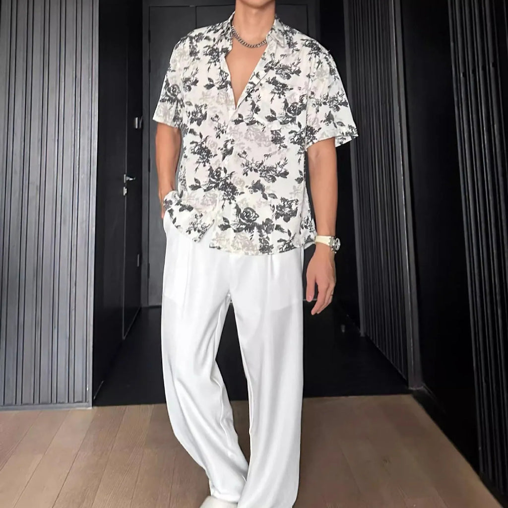 Loose-fitting floral print short sleeve shirt cardigan in black, laid flat.