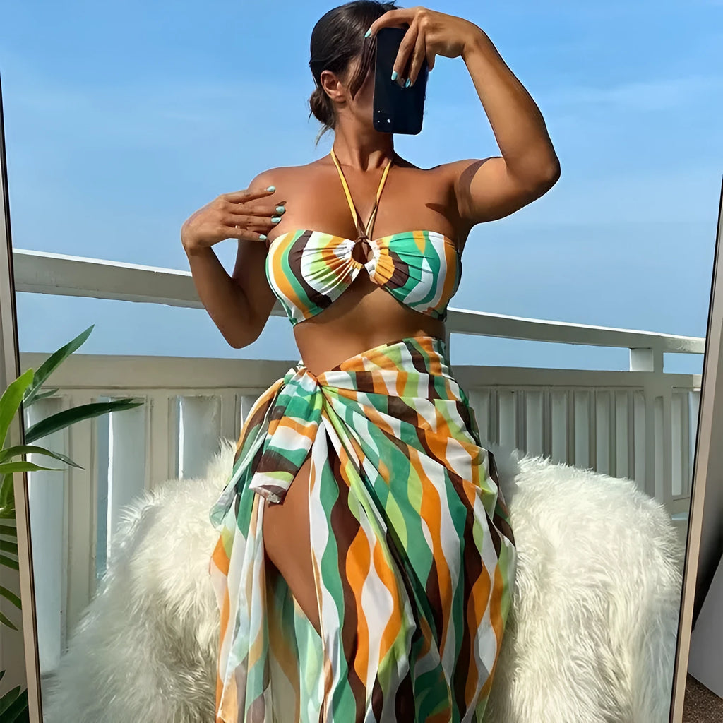 Women's yellow green printed three-piece bikini set with a matching skirt laid flat.