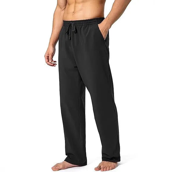Men's loose fit casual trousers in black polyester fabric on a hanger.