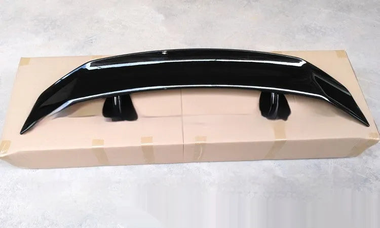A universal punch-free ABS plastic car tail wing spoiler showing bright black, white, and carbon pattern finish options.