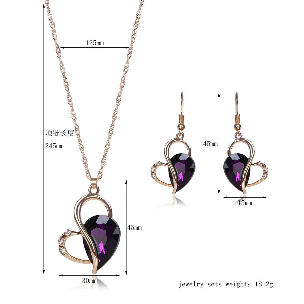 Rose gold two-piece jewellery set with heart pendant, water wave chain necklace, and earrings on display