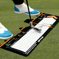 Black neoprene golf swing posture training pad on grass for stance alignment correction.