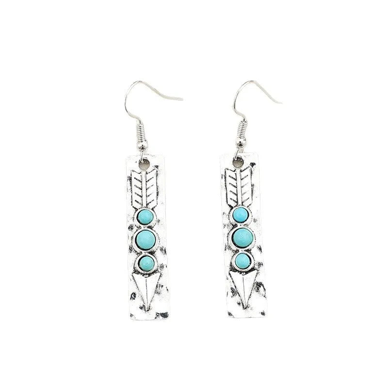 Silver geometric drop earrings with turquoise inlays and retro styling on white background