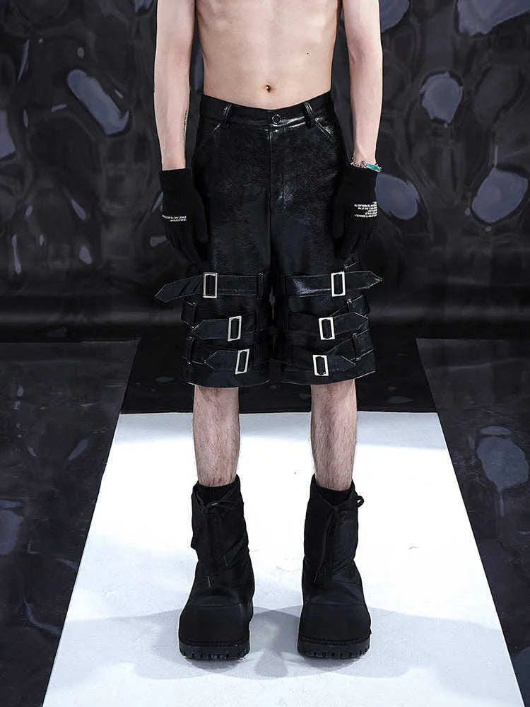 Men's black casual cropped shorts with a prominent leather ring detail on the front.
