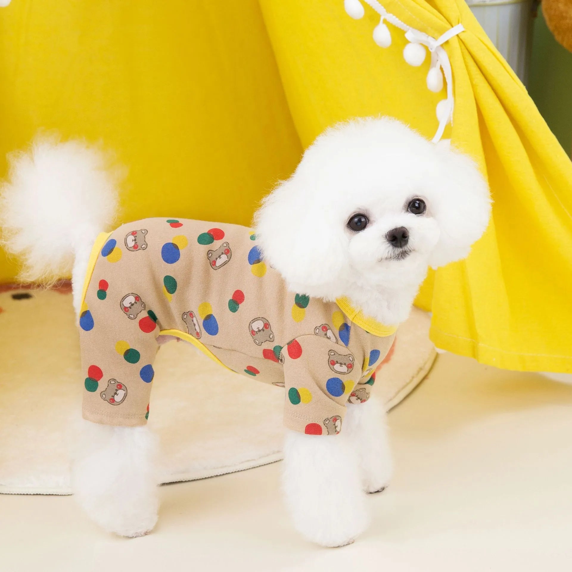 Beige dog t-shirt with a colourful cartoon ball bear design, showing a casual fit on a pet.