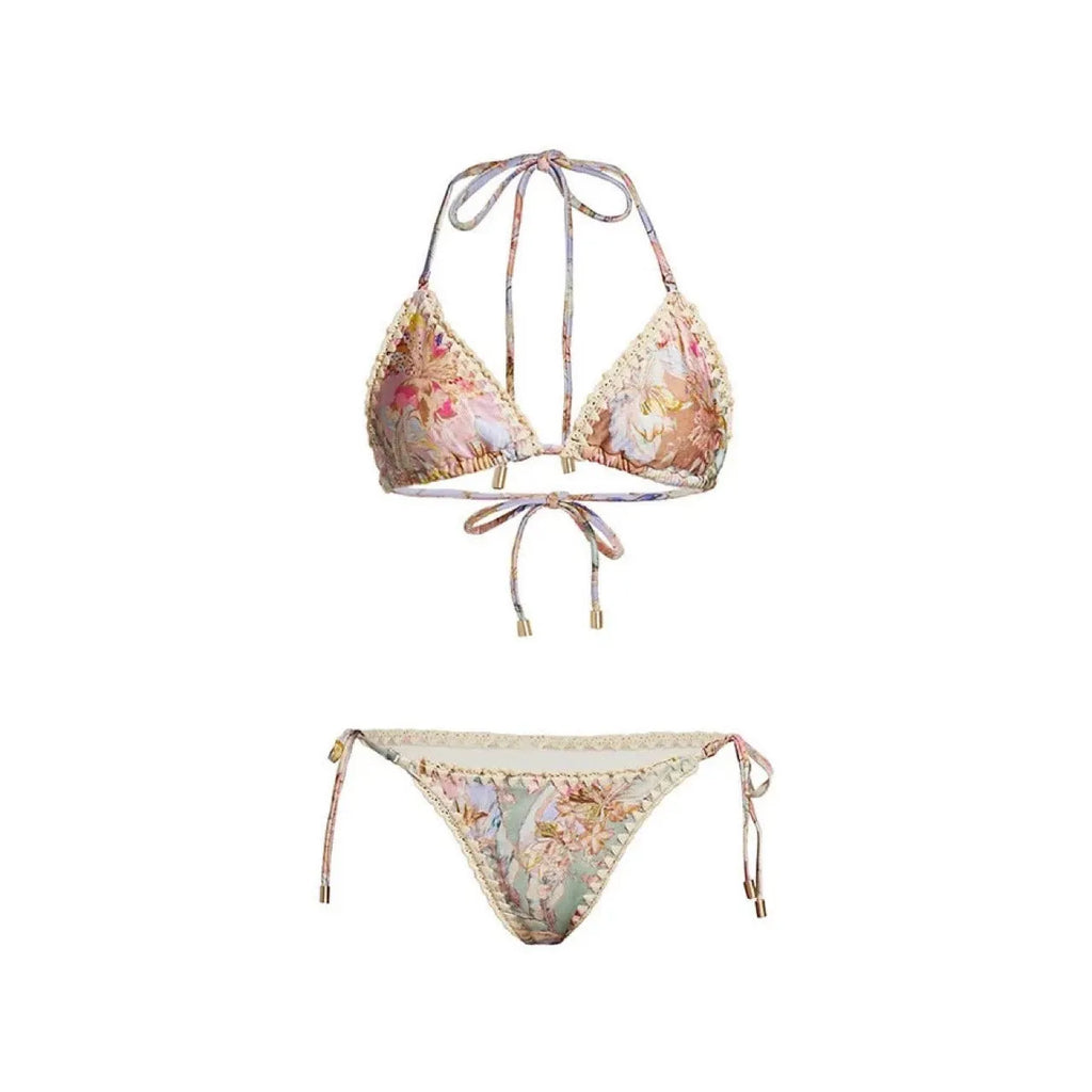 Women's creamy-white floral bikini swimsuit set with matching skirt on beach
