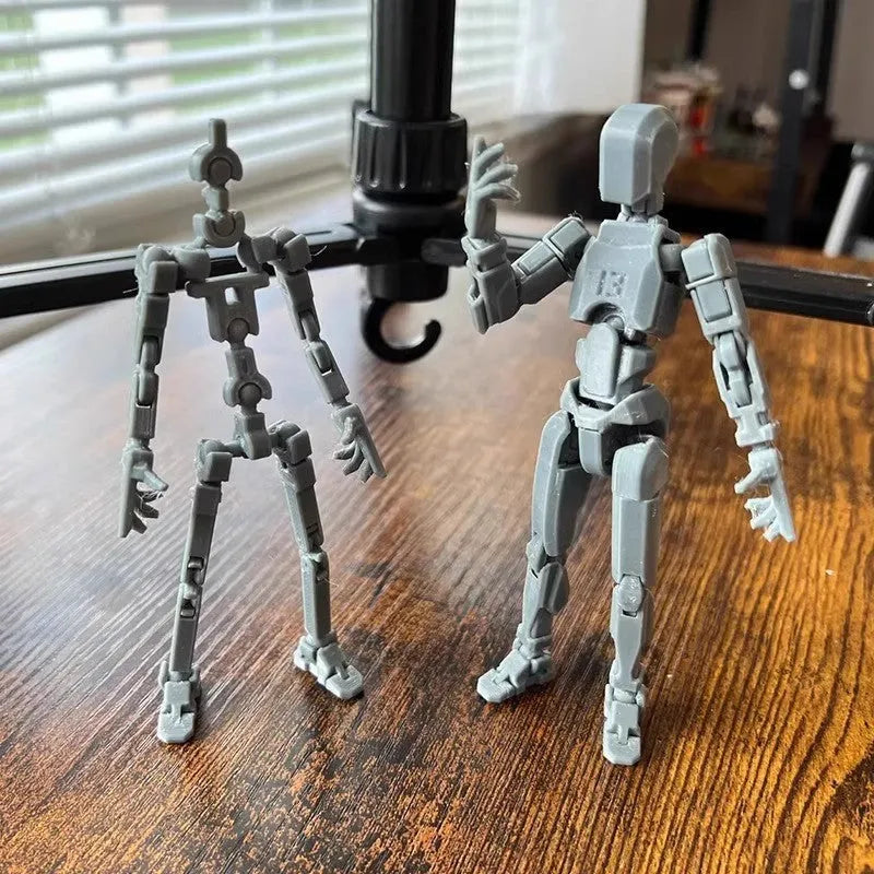 Multi-jointed 3D printed robot action model with movable limbs on a desk.