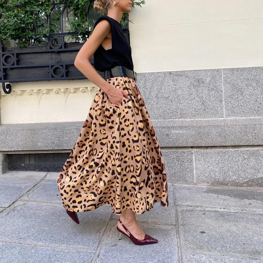 Brown leopard print women's A-line long skirt with a large hem, shown on a hanger.
