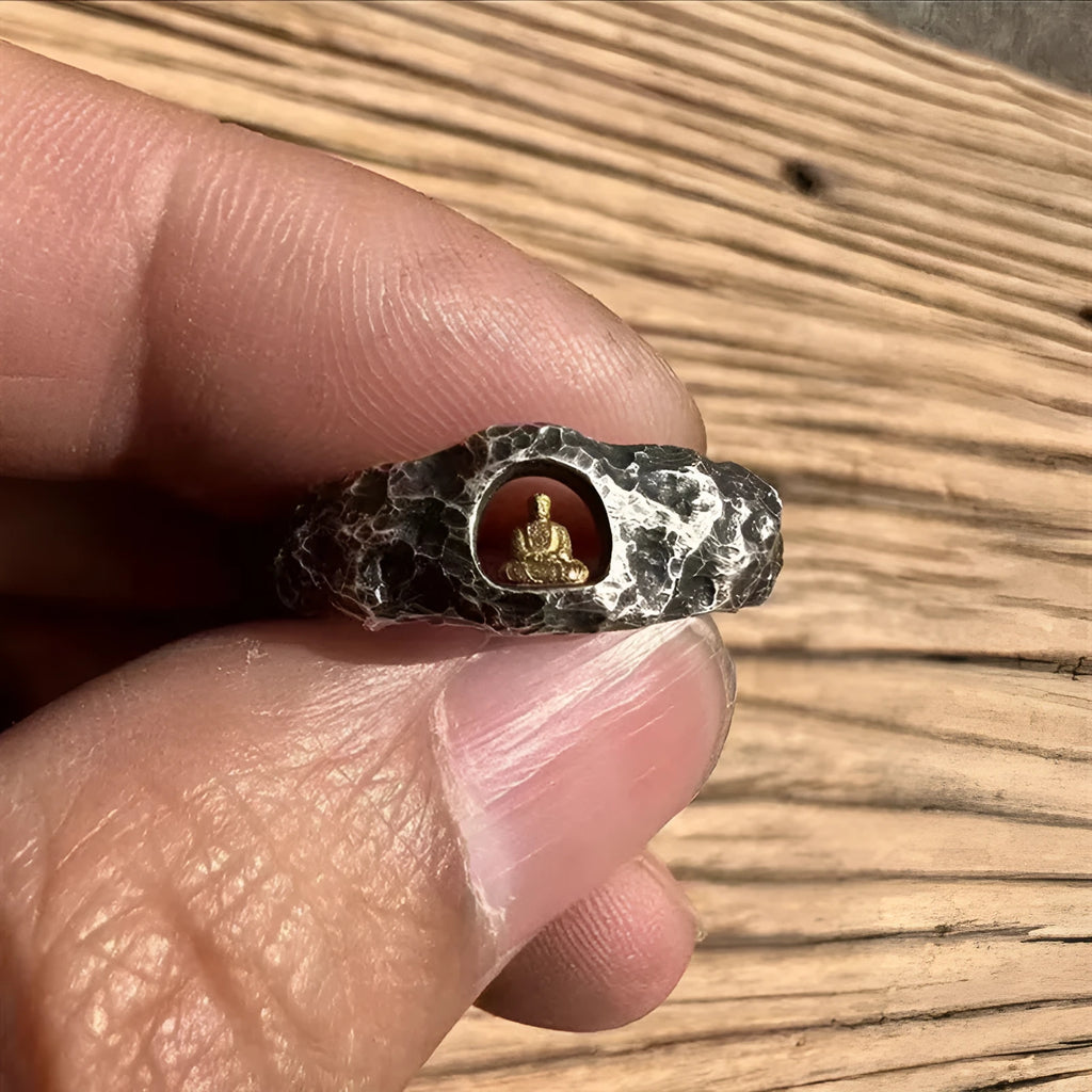 Close-up of a hand-forged copper Buddha ring with grotto design and rock texture on a size 8 finger.