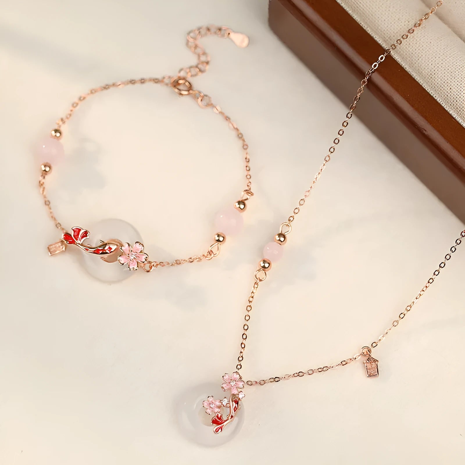 Close-up of a sterling silver bracelet with white chalcedony stones in a koi design on a wrist.