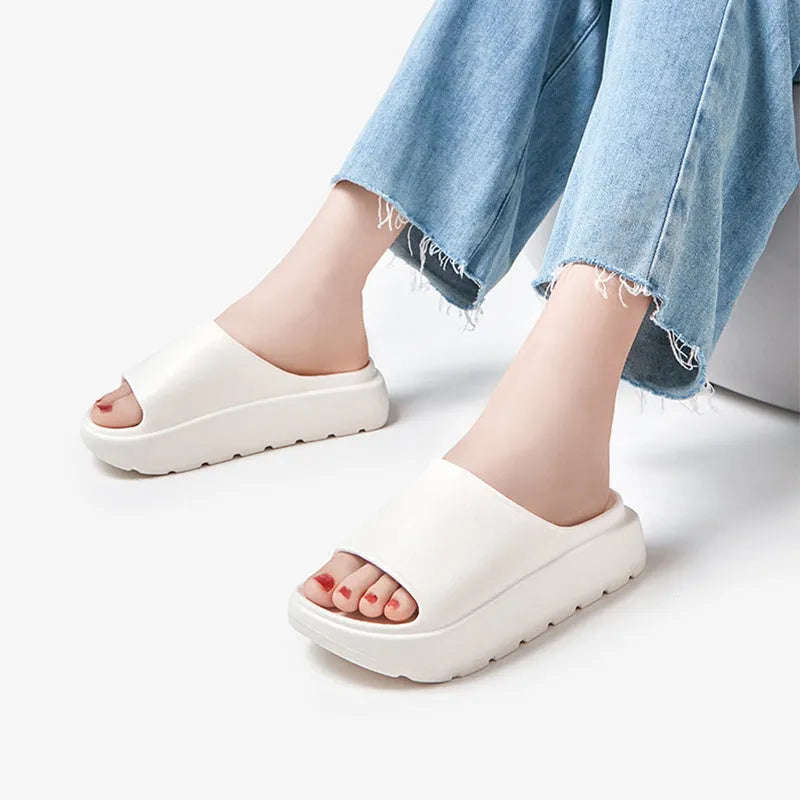 Women's beige fish mouth slippers with a thick 5.5cm EVA sole on a sandy beach.