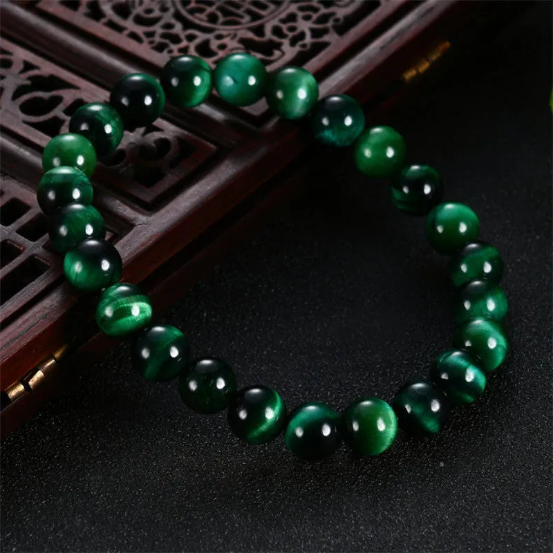 Green Tiger Eye stone beaded bracelet with polished geometric beads on a white background.