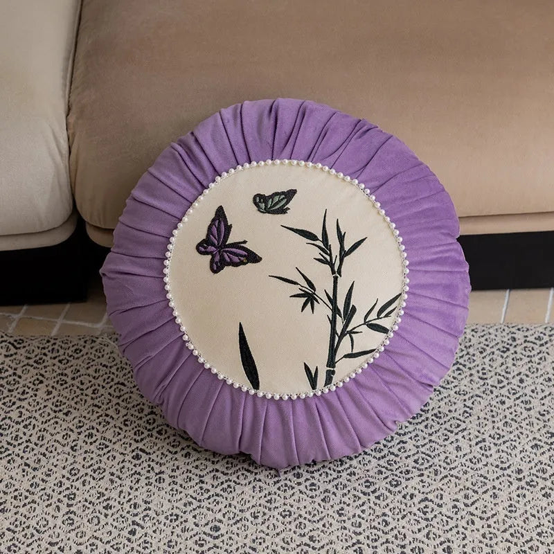 Square beige, black, and purple cushion with Chinese style embroidered butterfly pattern.
