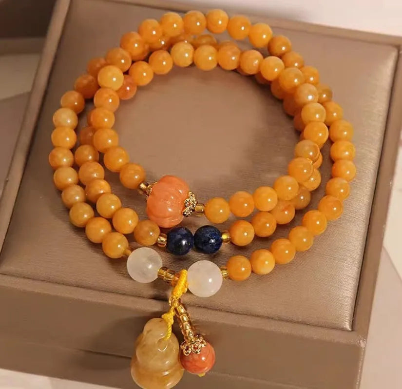 Women's multi-circle bracelet with three strands of natural Jinsi Jade beads and a resin flower calabash pendant on a white background