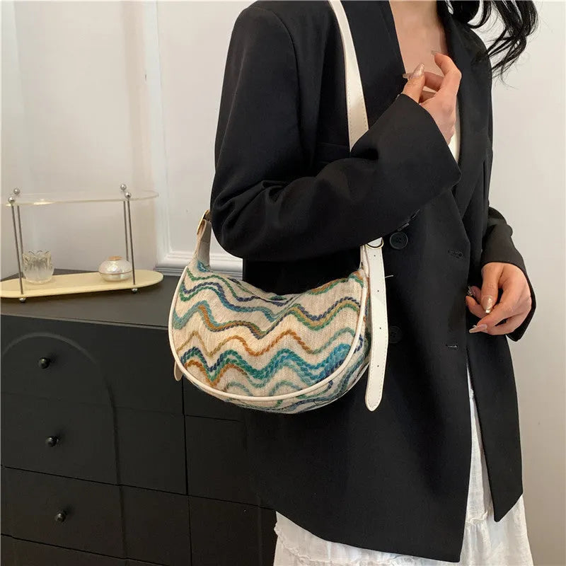 Women's straw woven crossbody bag showing woven texture and adjustable strap with internal phone and document pockets