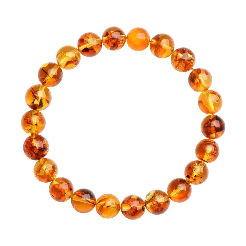 Natural yellow piebald amber bracelet with geometric beads on a wrist.