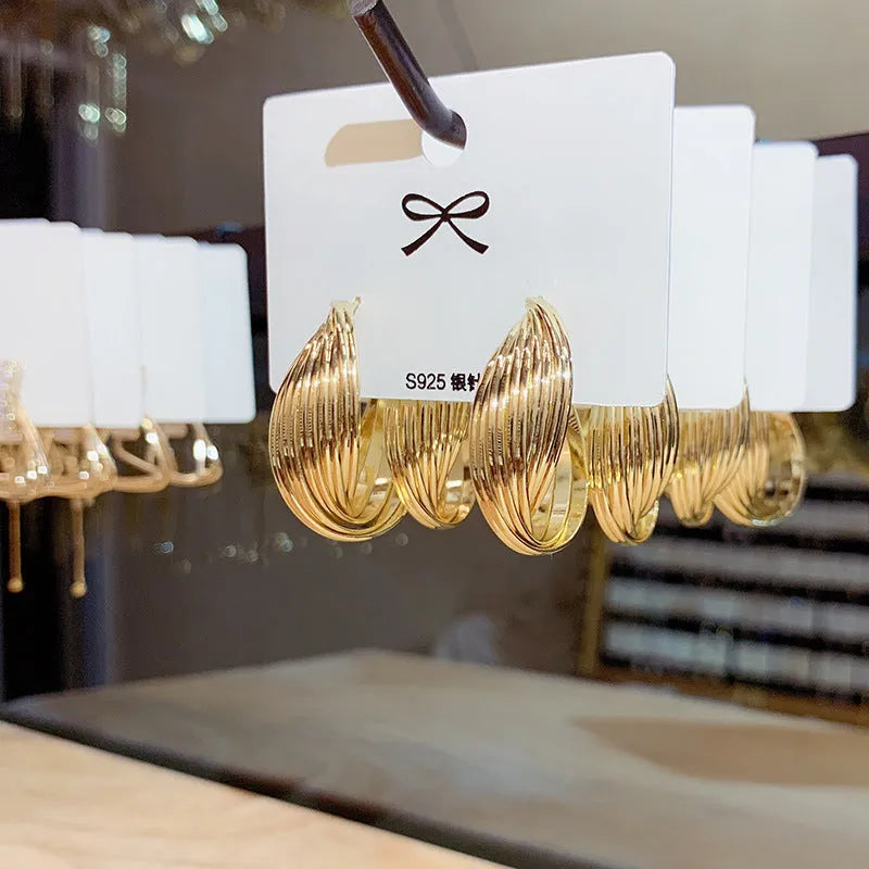 Twisted metal eardrop earring with real gold plating, geometric round shape, and stranded multi-layer design in gold colour