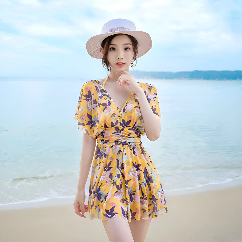 Yellow floral patterned women's one-piece swimsuit on a hanger, showing front design.