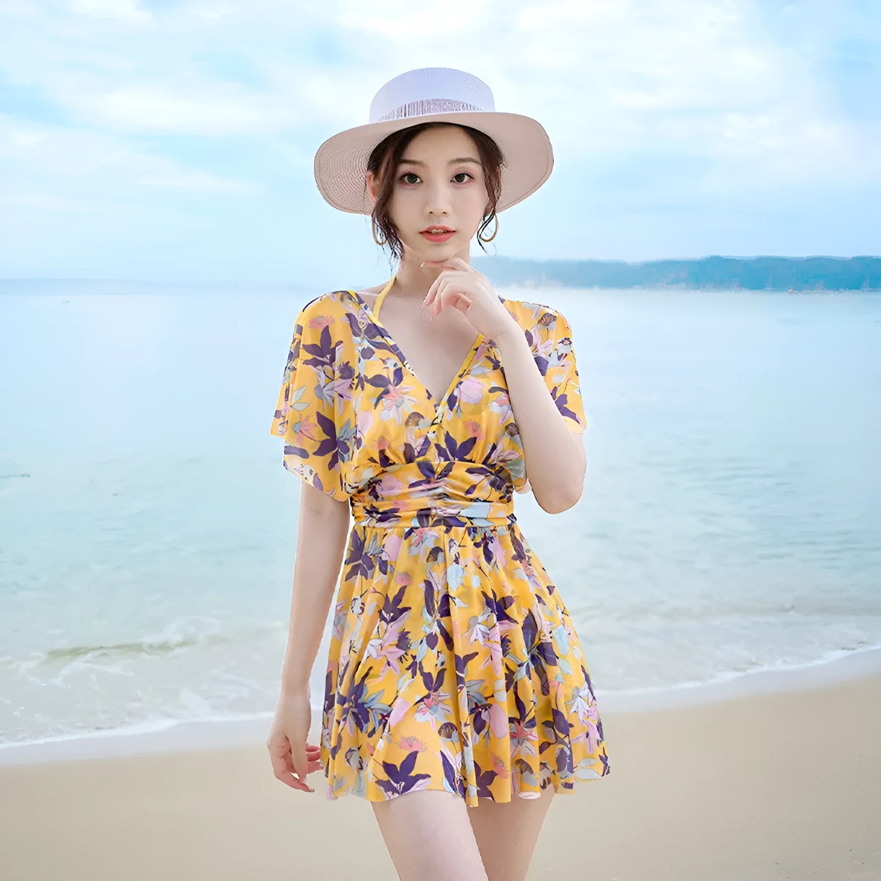 Yellow floral patterned women's one-piece swimsuit on a hanger, showing front design.