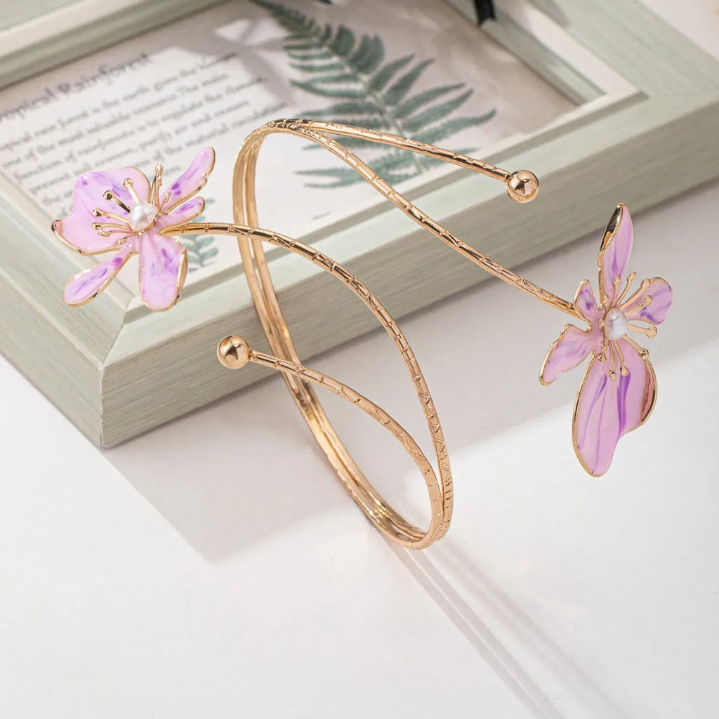 Pink alloy armband with hollow line pattern, shown as an open cuff bangle.