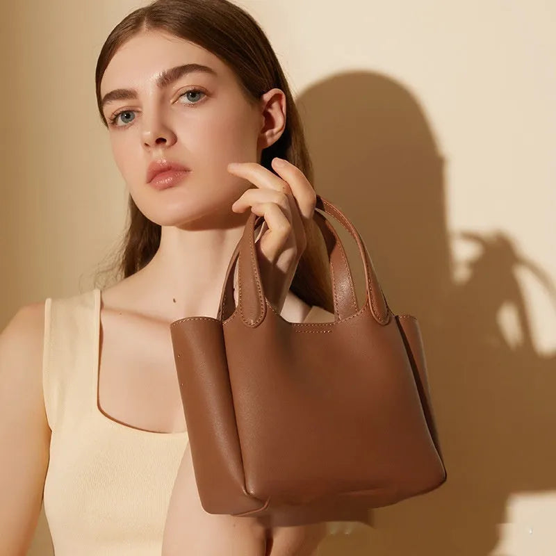 Brown cattlehide leather cross body bucket bag with square vertical design and slit pocket