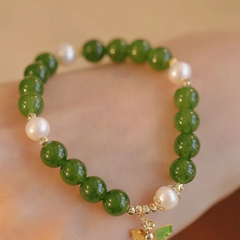 Close-up of a green chalcedony bracelet with round geometric beads on a wrist.