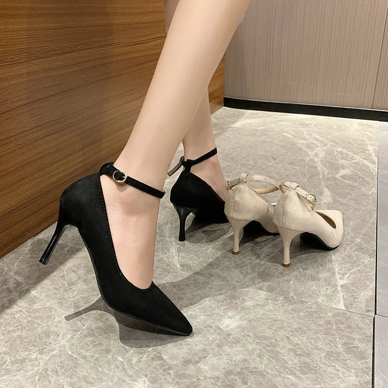 Women's black stiletto pump shoes with a silver buckle detail on the side.