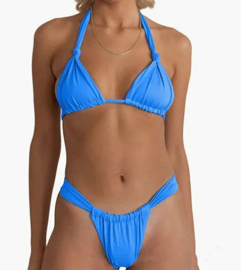 Women's pink pleated split strap bikini swimsuit with knotted detail on a solid colour background.
