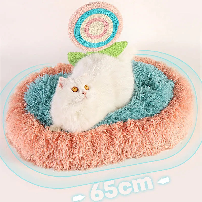 Pink elliptical plush cat bed with a removable, washable cover on a wooden floor.