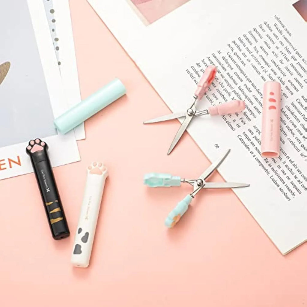 Cat paw design mini folding safety scissors in four colours: black, blue, pink, and white.