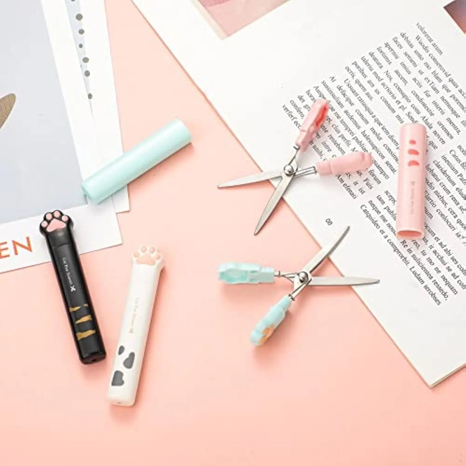 Cat paw design mini folding safety scissors in four colours: black, blue, pink, and white.