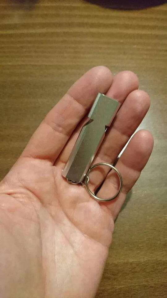 Gold and silver aluminium alloy double-hole survival whistle on a keyring.