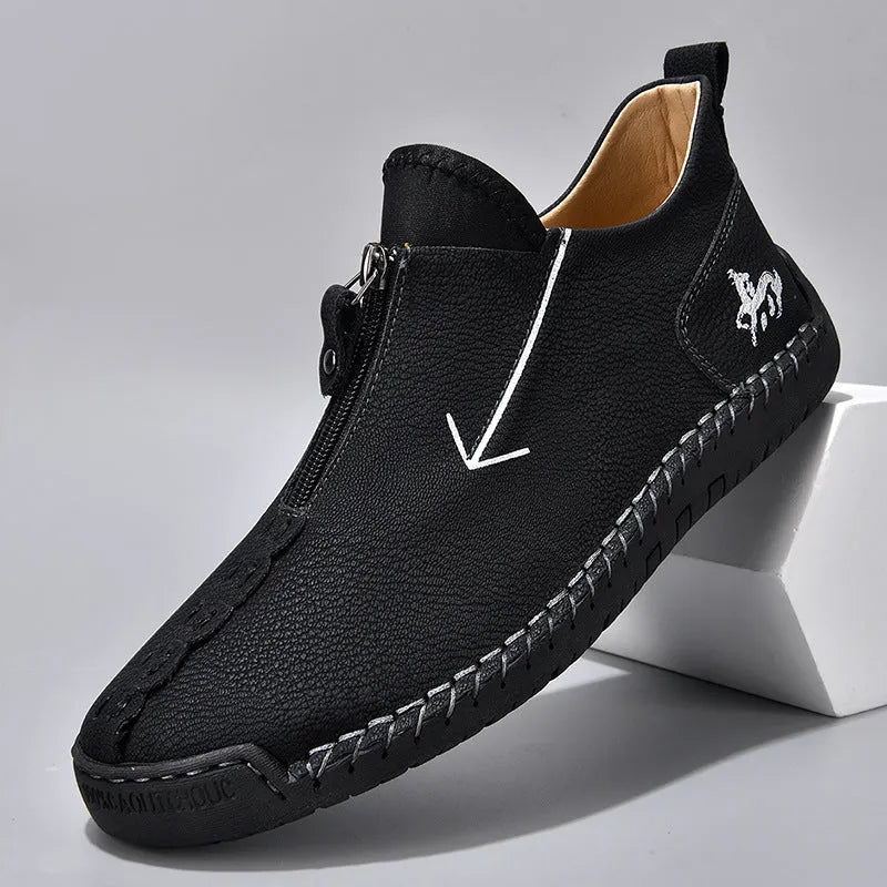 Men's black leather zip-up martin boots with round toe and low heel on a rubber sole.