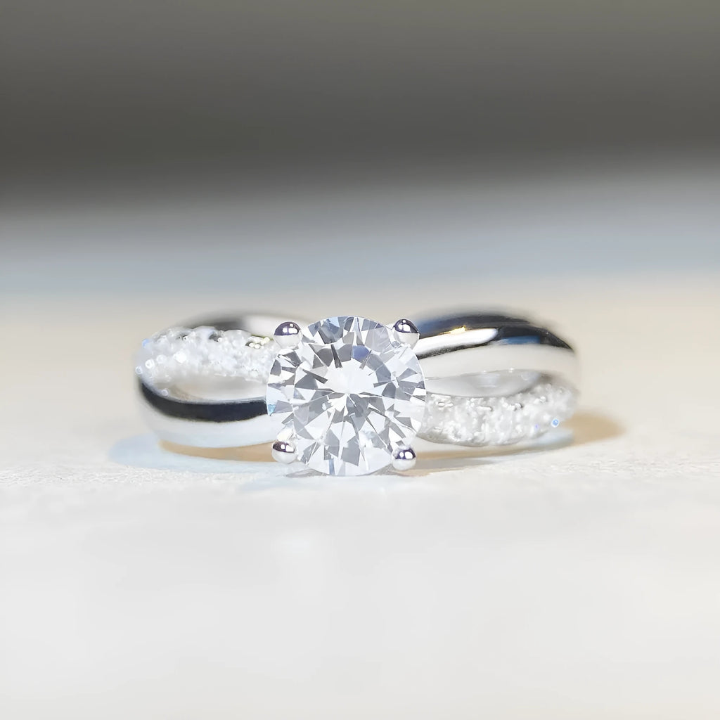 Silver geometric cross ring with a 1 karat moissanite stone in a twisted four-claw setting