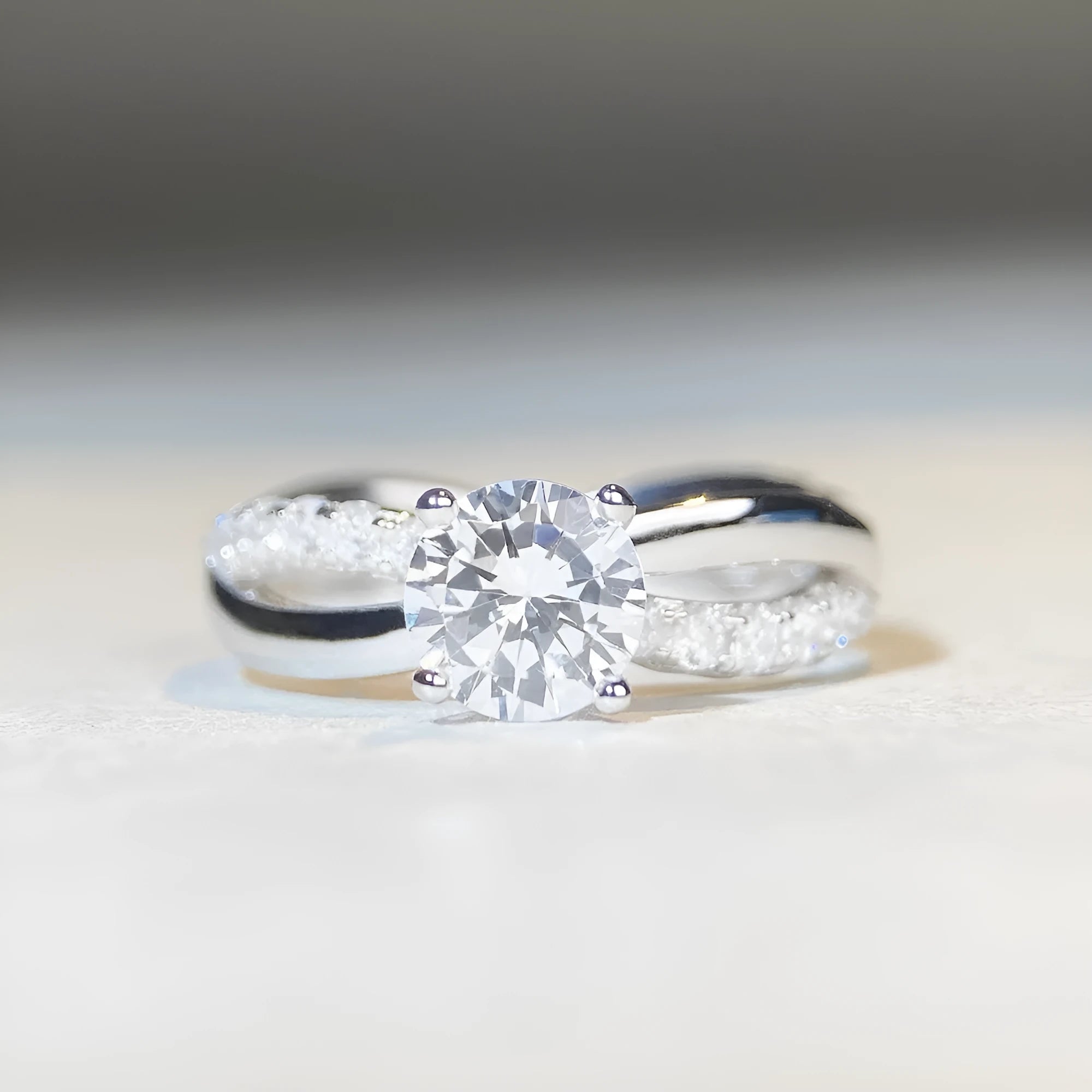Silver geometric cross ring with a 1 karat moissanite stone in a twisted four-claw setting