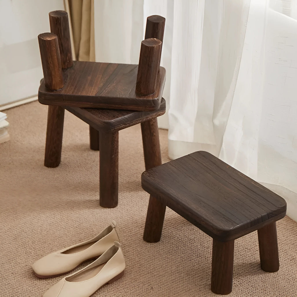 Solid wood distressed finish shoe changing stool on a wooden floor