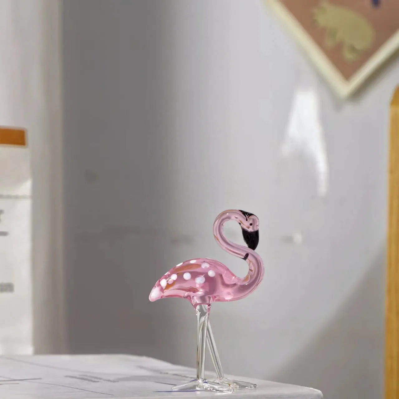 Pink crystal simulation flamingo decorative ornament on a table for home decor or gifting.