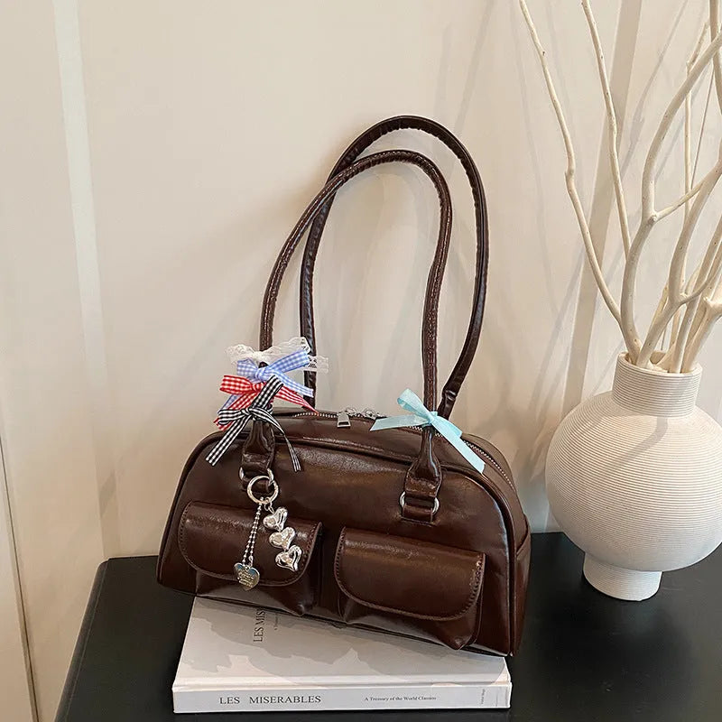 Retro pillow-shaped women's handbag in PU leather with a one shoulder strap, shown in a choice of colours.