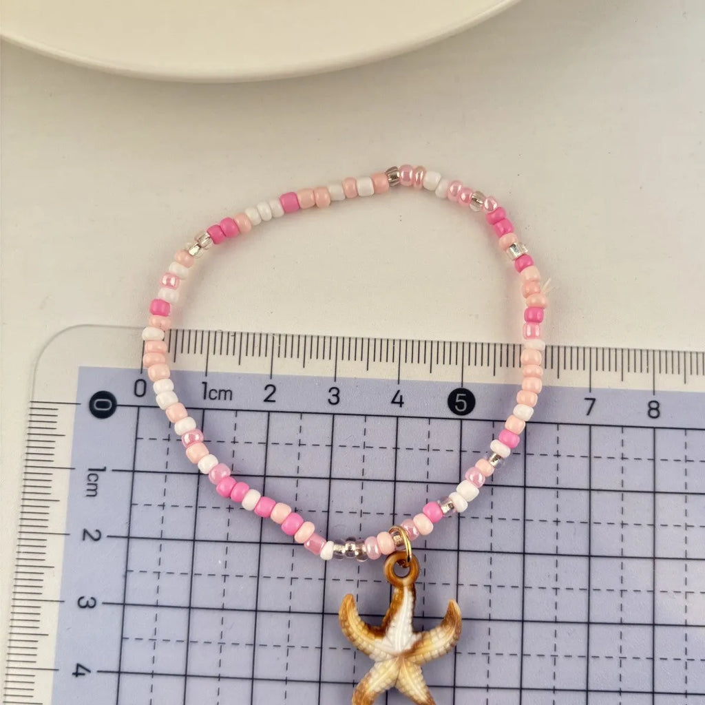 Handmade acrylic rice bead elastic bracelet in doll shape with flower detail, available in multiple colours