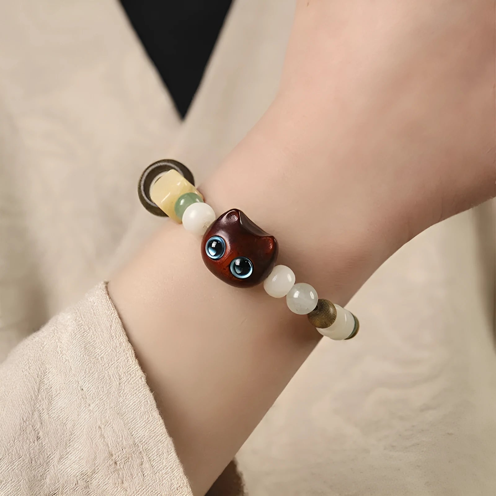 Hand-woven bracelet with bodhi seeds, jade, and wood featuring cartoon cat charm in multiple colour options