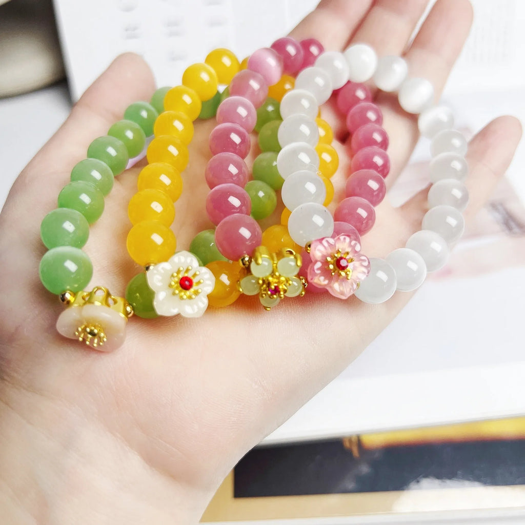 Handmade glass bead bracelet with floral design in yellow, pink, white, or green.