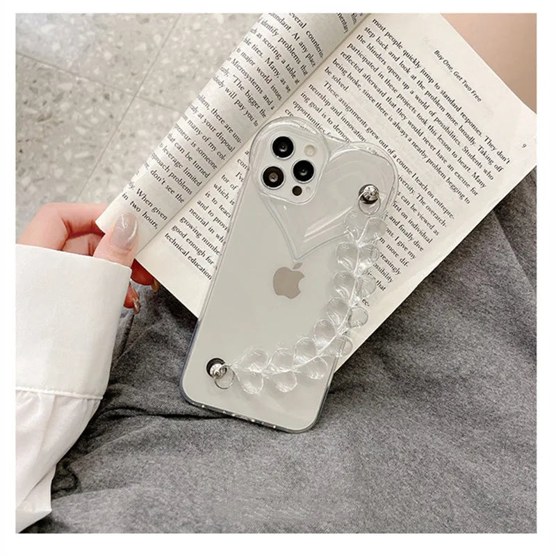 Transparent soft TPU iPhone case with a built-in clear love heart charm and chain.