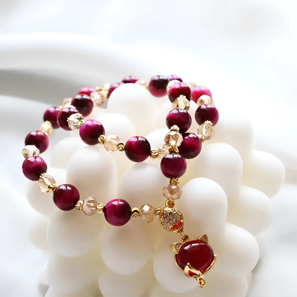 Handmade Tigereye stone bracelet on wrist, showing single chain and rose red fox charm.