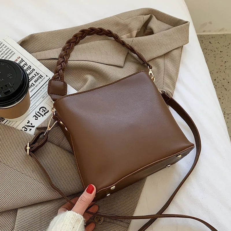 Retro khaki PU leather crossbody bucket bag with woven detail and a brown strap.