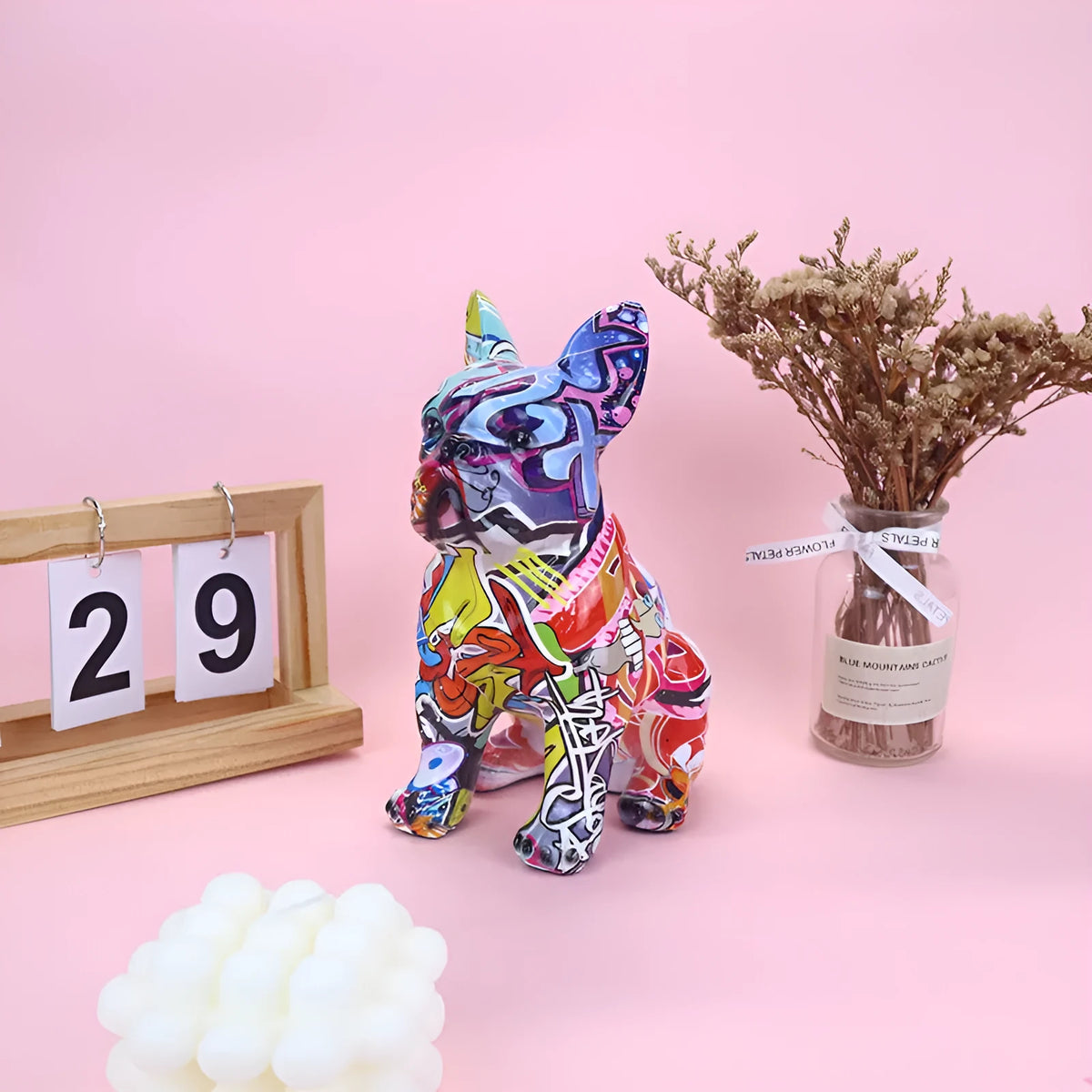 Modern graffiti-colour French bulldog resin statue on a shelf.
