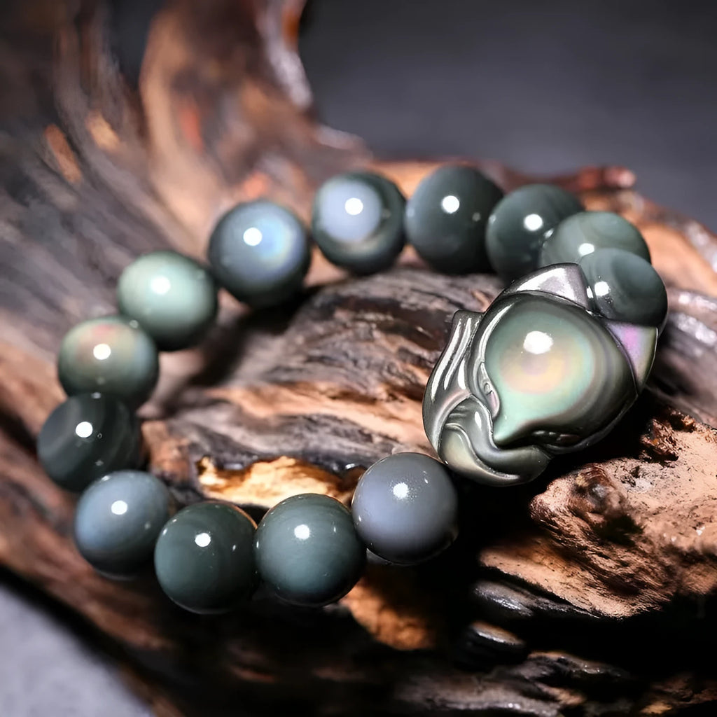 Obsidian stone bracelet with carved fox design on a central bead, shown in multiple size options.