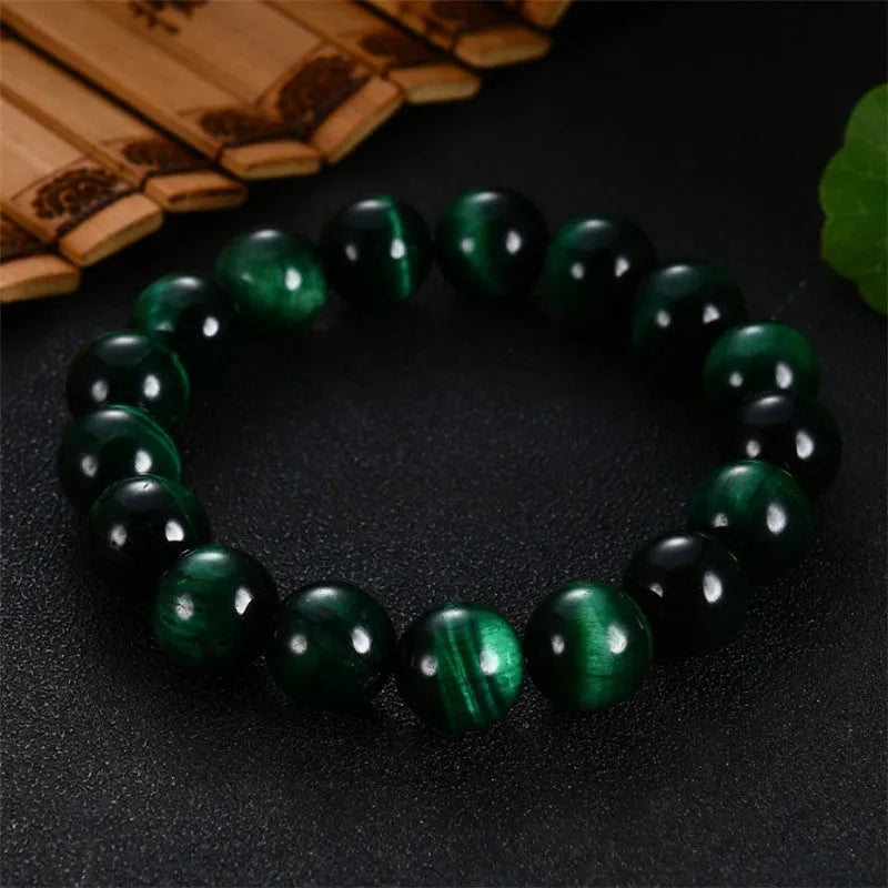 Green Tiger Eye stone beaded bracelet with polished geometric beads on a white background.
