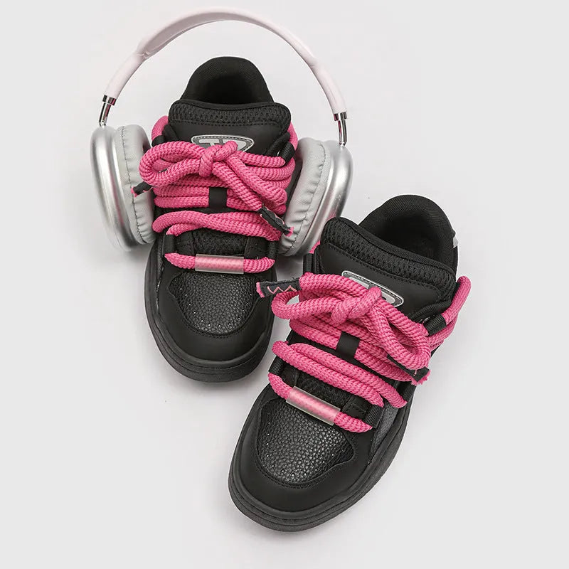 Pair of thick-soled casual lace-up trainers in a solid colour on a white background.