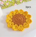 A hand-woven circular wool coaster with a floral pattern, shown as a single piece.